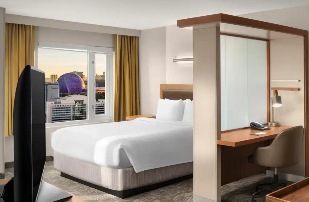 a hotel room with a bed and a desk and a window at SpringHill Suites by Marriott Las Vegas Convention Center in Las Vegas