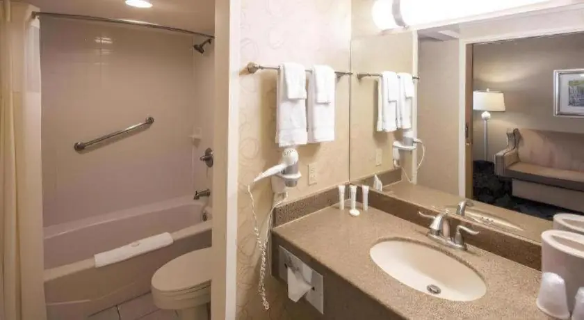 a bathroom with a sink and a toilet and a mirror at Orleans Hotel and Casino in Las Vegas