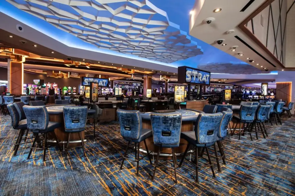 a casino with tables and chairs in a casino at The STRAT Hotel, Casino & Tower in Las Vegas