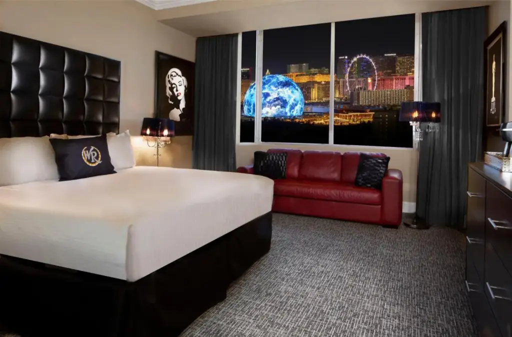 a hotel room with a bed and a red couch at Westgate Las Vegas Resort and Casino in Las Vegas