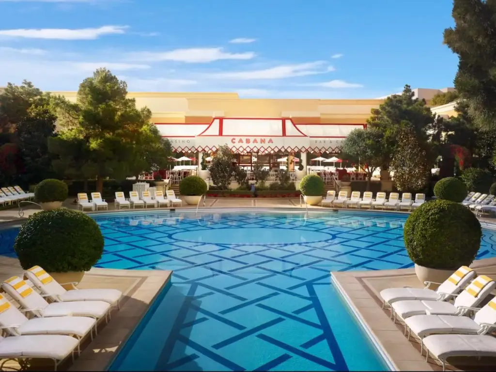 a swimming pool with lounge chairs and a building at Wynn Las Vegas in Las Vegas