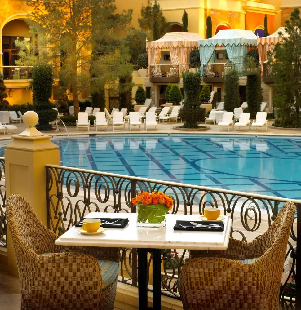 a table and chairs in front of a swimming pool at Wynn Las Vegas in Las Vegas