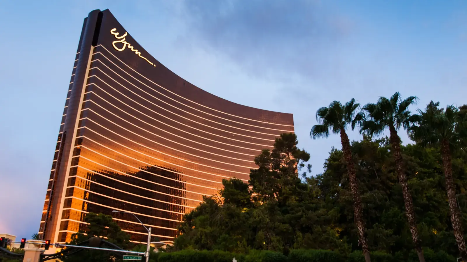 Wynn Las Vegas glowing gold at sunset with palm trees